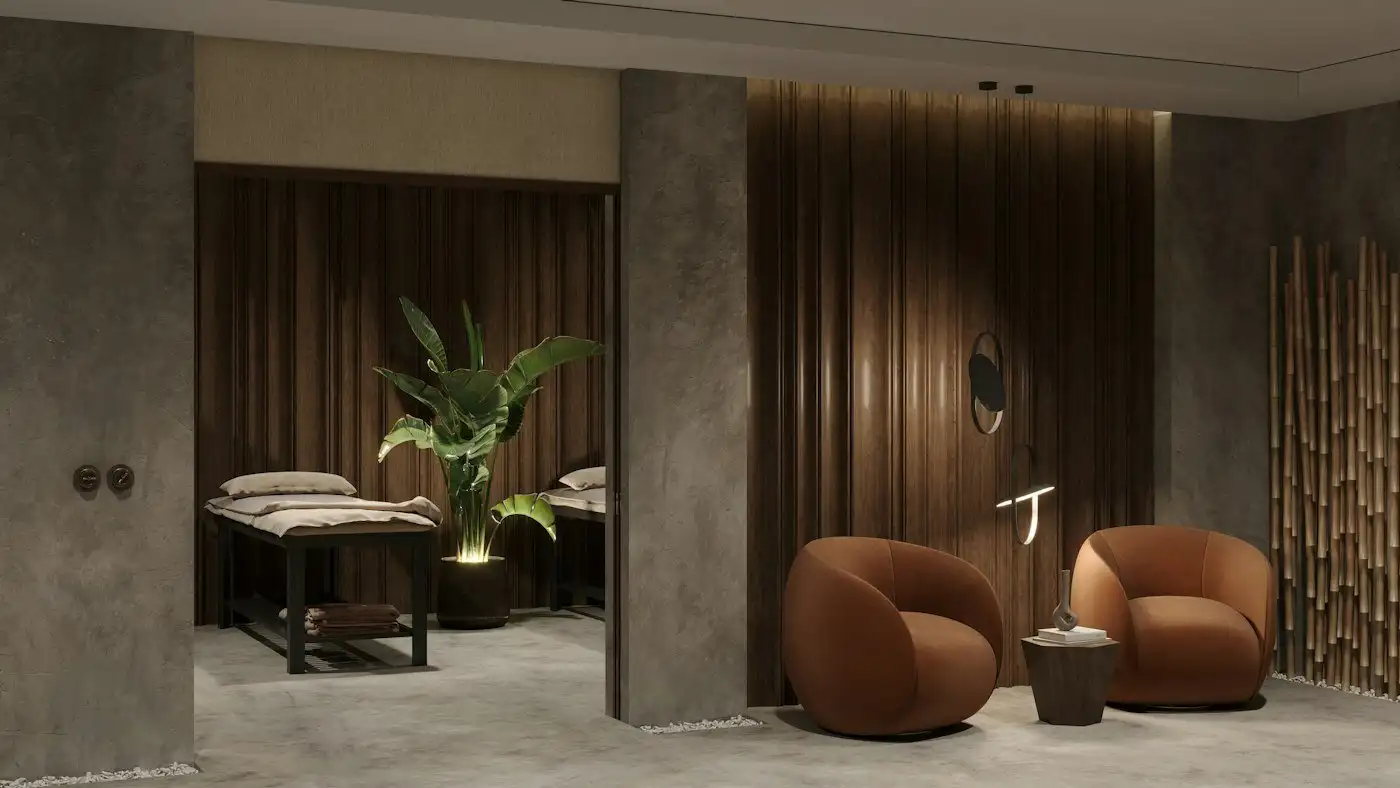A spa lounge with two rounded terracotta armchairs, wood-paneled walls and two treatment beds beyond
